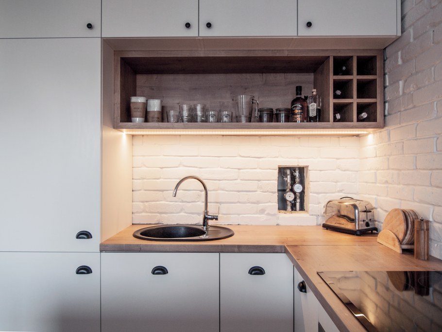 Белая кухня с деревянной столешницей и фартуком