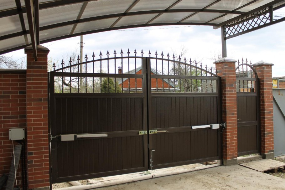 Забор из кирпича и профнастила с ковкой