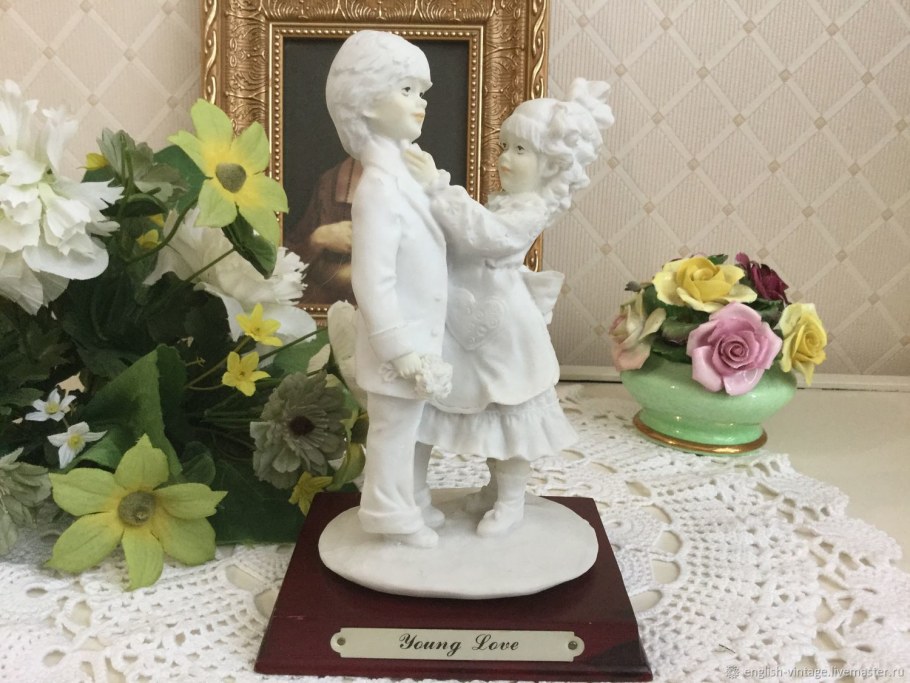 Статуэтка и цветы на столе фото