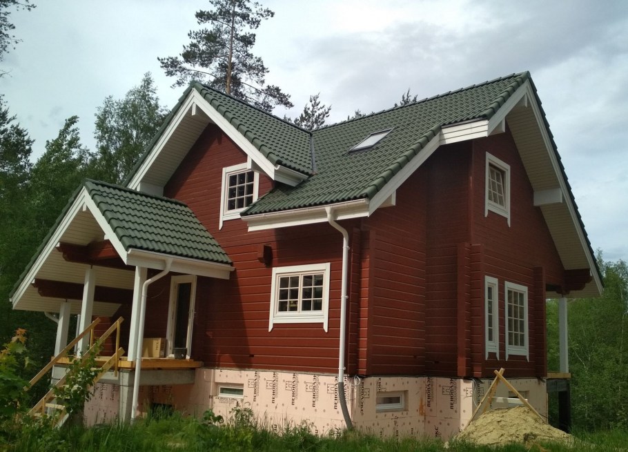 Брусовой дом с зеленой крышей