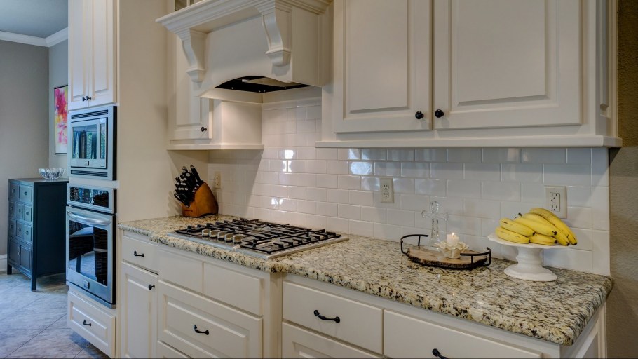 Белая кухня с зеленым фартуком