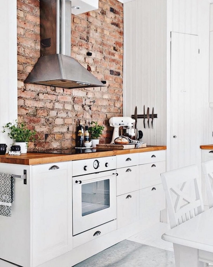 Белая кухня с деревянной столешницей и кирпичным фартуком