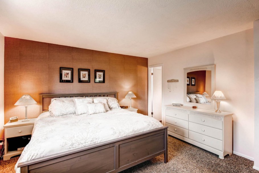 Спальня с ковролином и рыжей мебелью