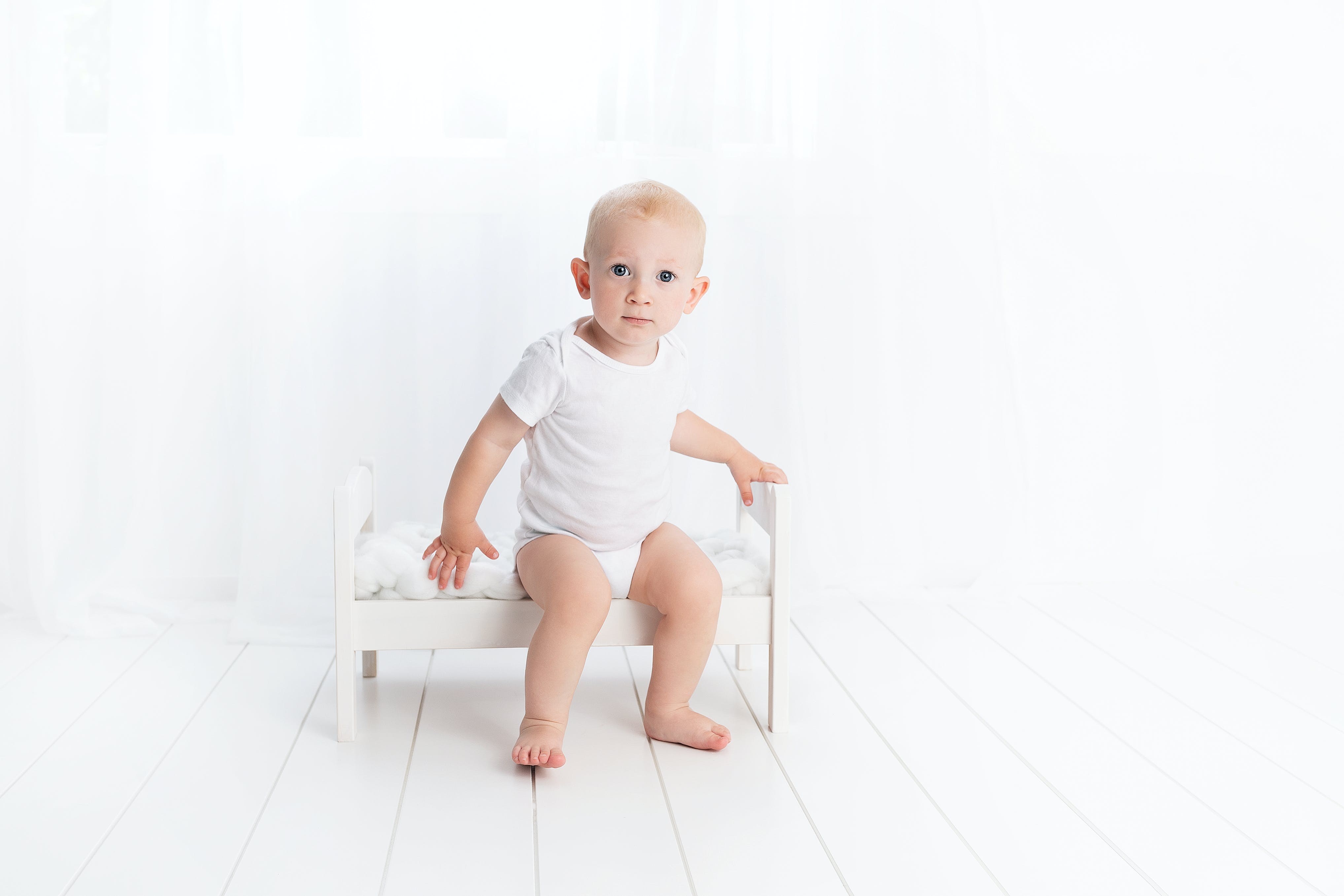 Ребенок сидит на ножках. Малыш в белом. Малыш сидит. Дети на белом фоне. Малыш на белом фоне.
