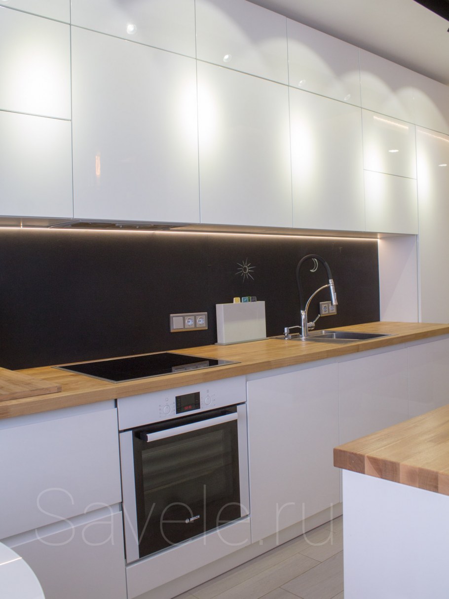 Белая кухня с деревянной столешницей и барной стойкой