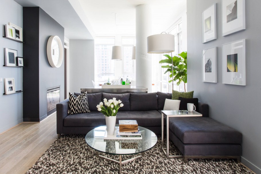 Светлая гостиная в современном стиле с темно серым диваном