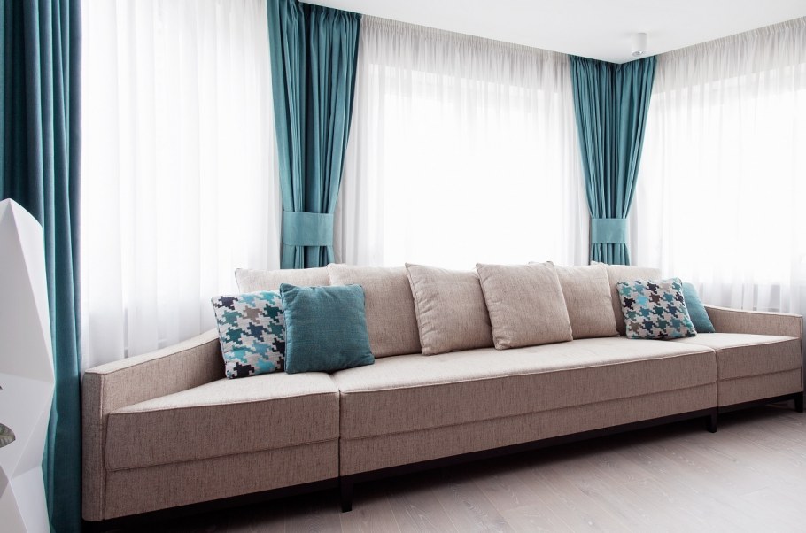 Пудровый диван и бирюзовые шторы