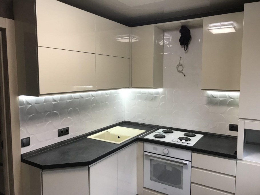 Белая угловая кухня с черной столешницей