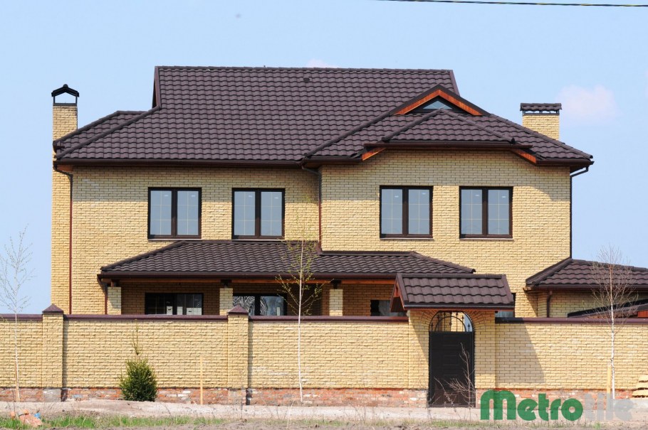 Дом из бежевого кирпича с коричневой крышей