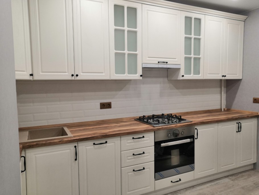 Кухня с белыми фасадами и деревянной столешницей