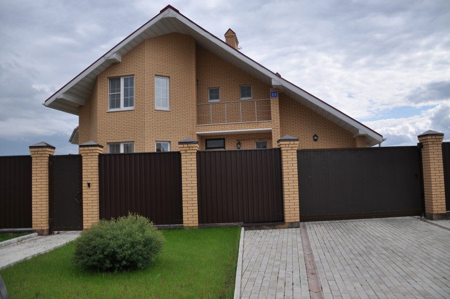 Кирпичный дом с заборо