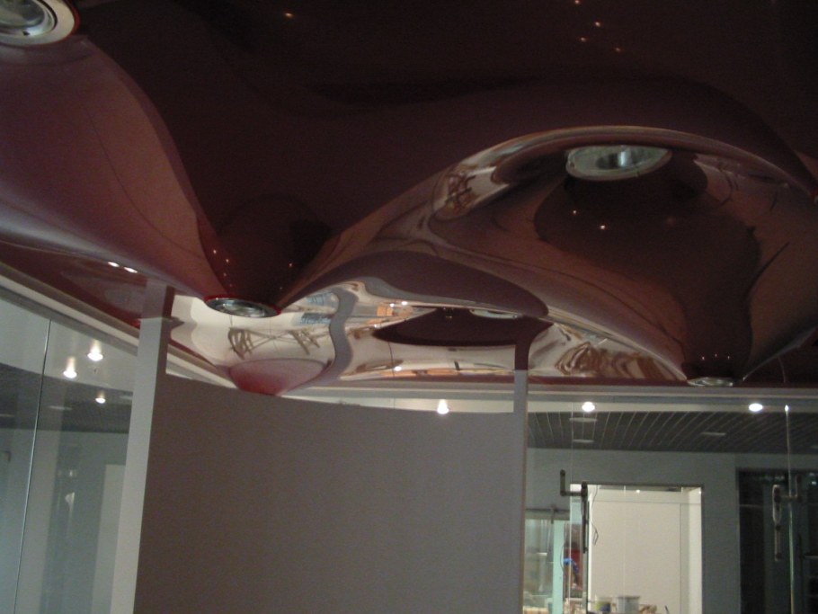 Бежевый натяжной потолок в спальне с люстрой