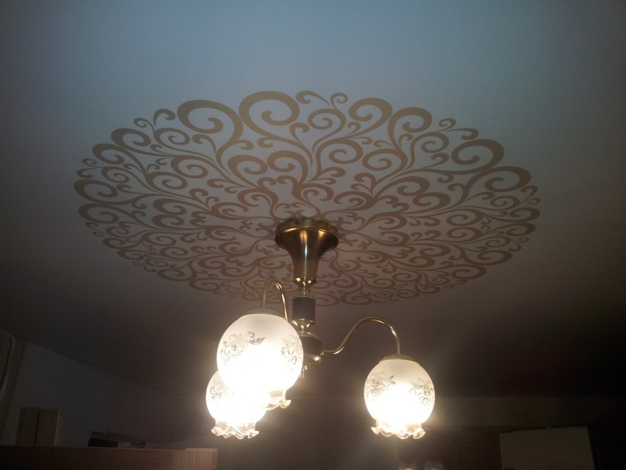 Натяжные потолки с орнаментом вокруг люстры