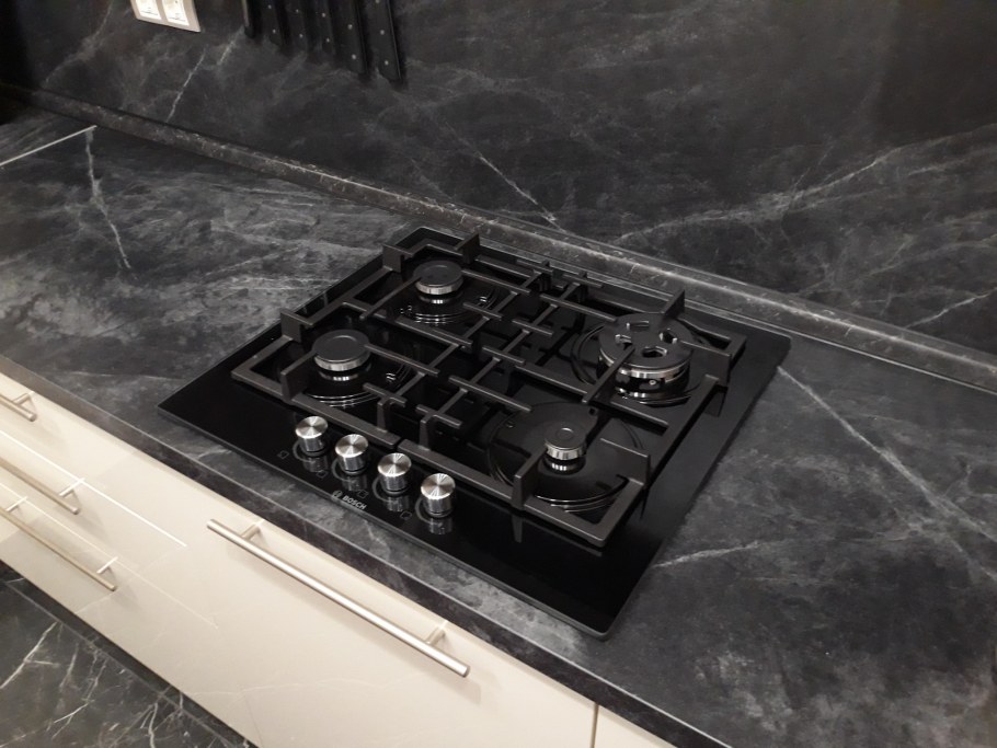 Белая варочная панель на черной столешнице