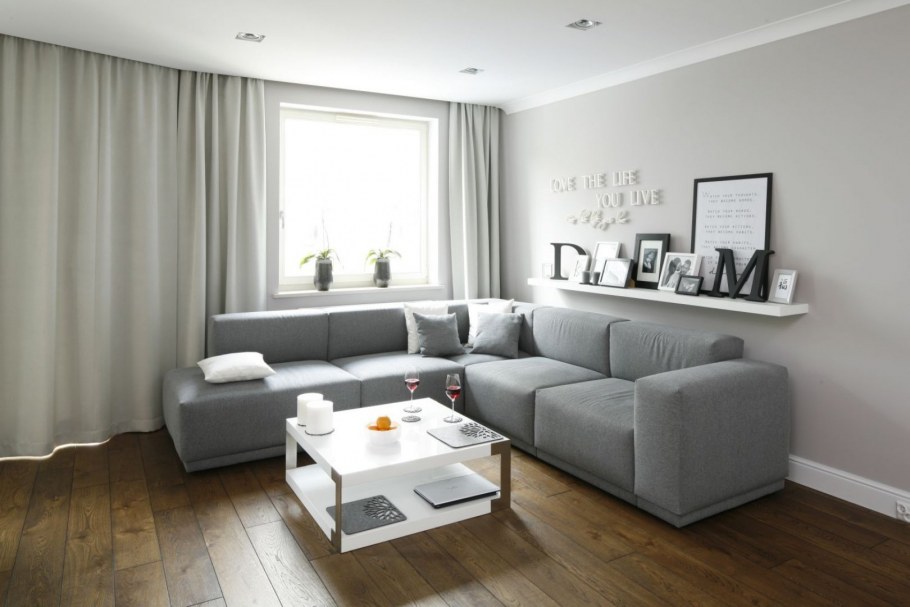 Интерьер гостиной с серым диваном и светлыми обоями