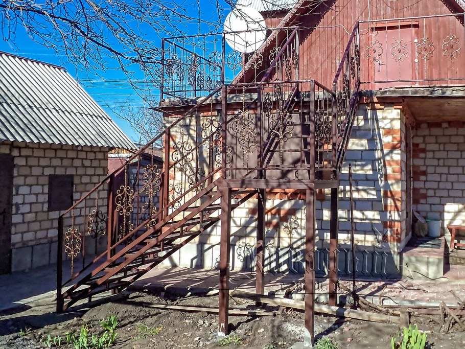 Наружная лестница на второй этаж на даче с крышей