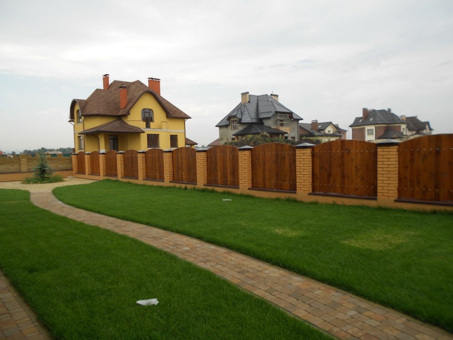 Покрашенный деревянный дом с деревянным забором