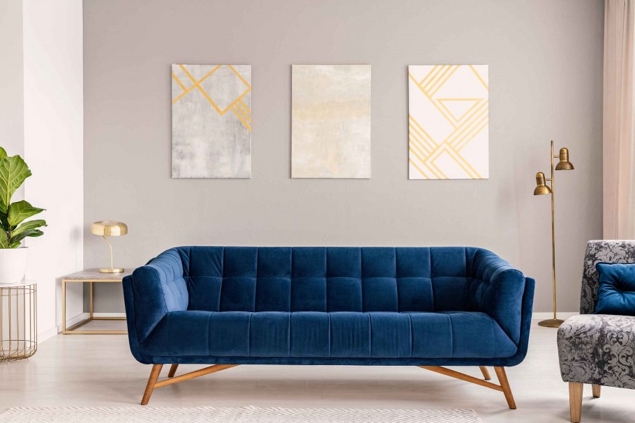 Благородно синий диван на ножках в интерьере гостиной