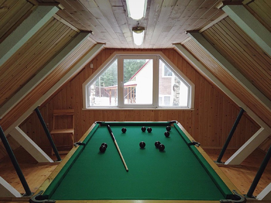 Интерьер бильярдной комнаты в частном доме на мансарде