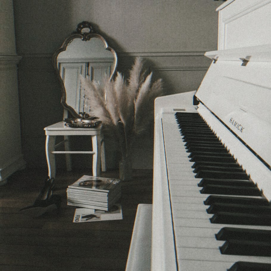 Белое пианино в интерьере посреди комнаты