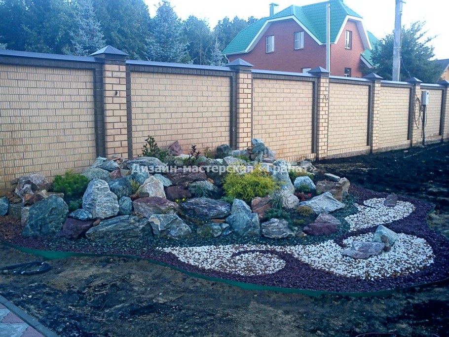 Альпийские горки возле забора