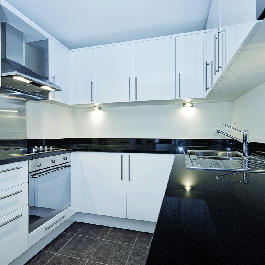 Белая глянцевая кухня с черной столешницей