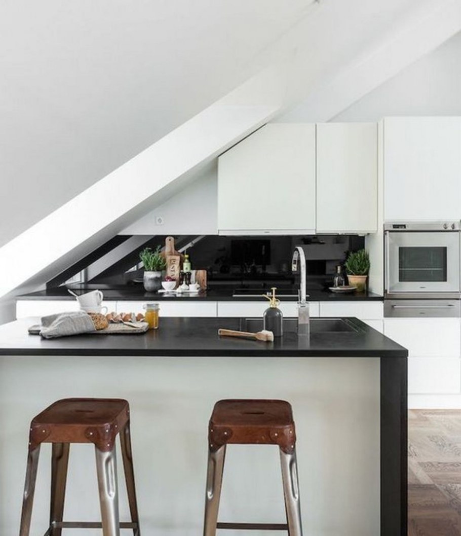 Кухня в мансарде со скошенным потолком над рабочей поверхностью