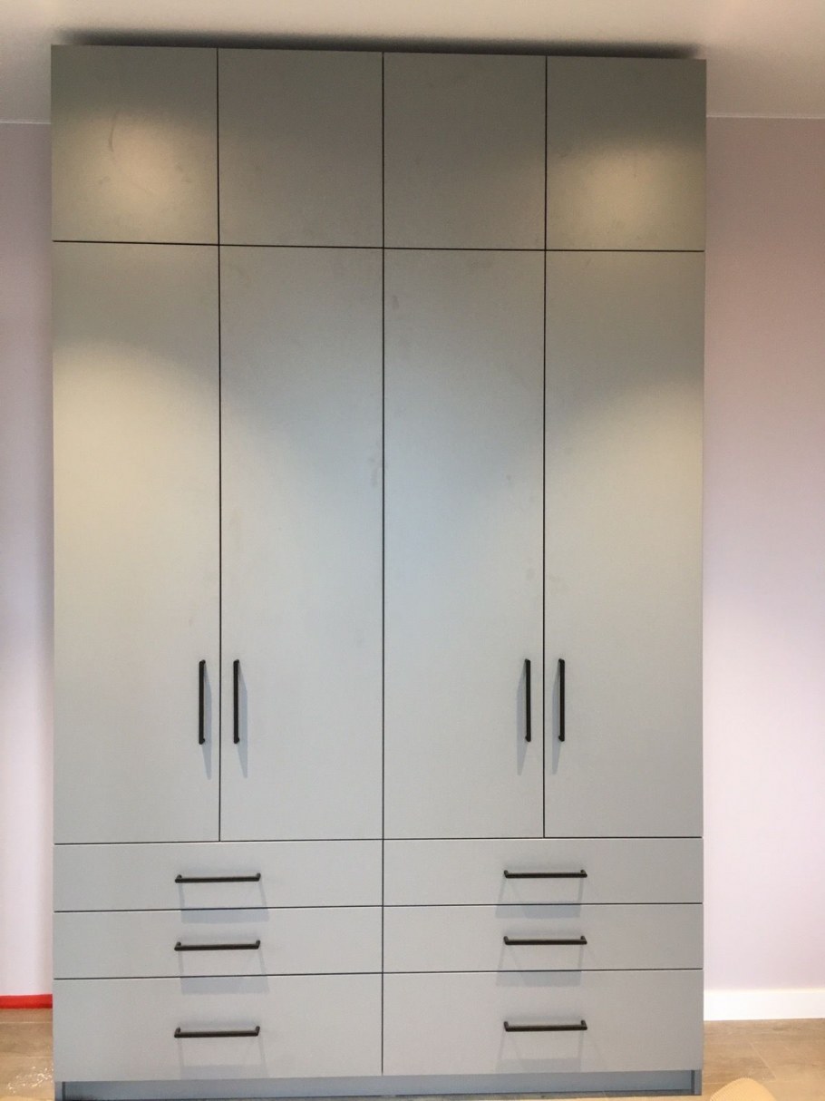 Серый шкаф с черными ручками