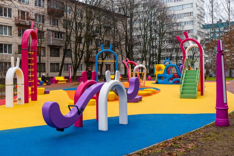 Старая детская площадка во дворе многоэтажного дома